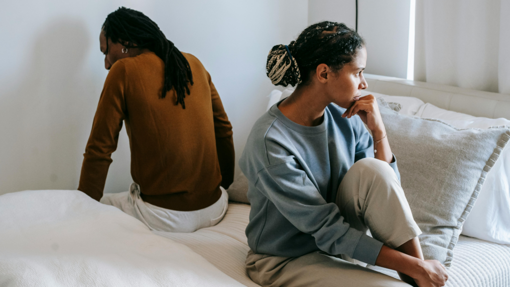 couple facing opposite sides of the bed