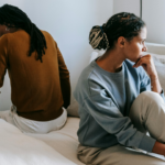 couple facing opposite sides of the bed