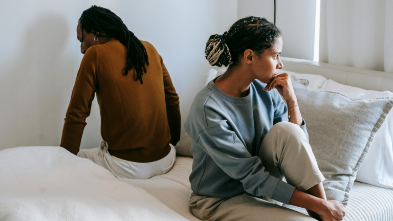 couple facing opposite sides of the bed