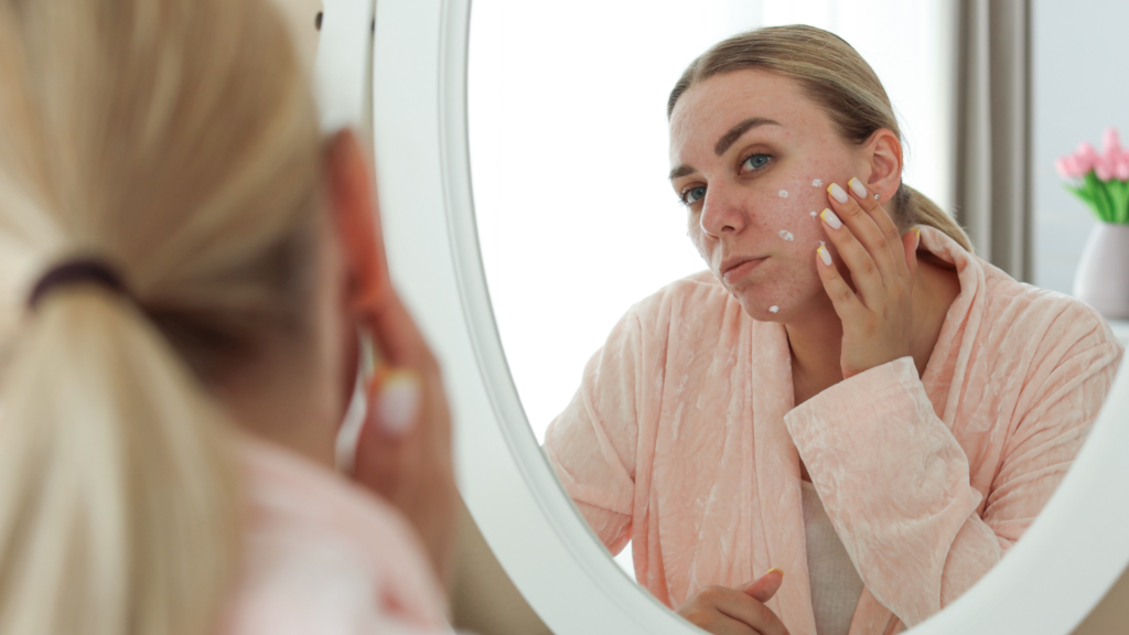 woman looking at face in mirror