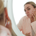 woman looking at face in mirror