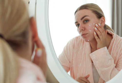 woman looking at face in mirror