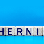 wooden blocks saying hernia on blue background