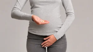 woman covering her private area and holding medications pills in other hand