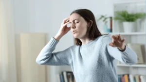 woman holding her head dizzy trying not to lose balance as she stands up postural orthostatic tachycardia syndrome pots