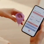 woman looking at a period tracker menstrual cycle app on phone