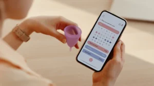 woman looking at a period tracker menstrual cycle app on phone