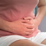 woman clutching abdomen in pain
