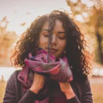 woman with curly hair in cold autumn weather with scarf