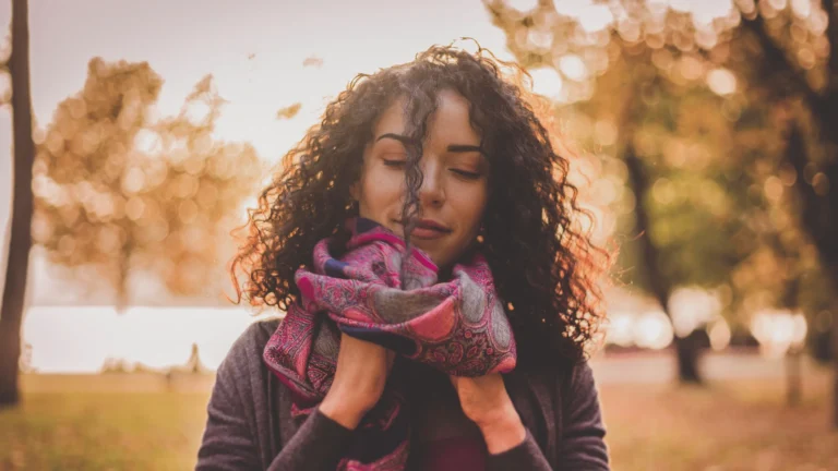 woman with curly hair in cold autumn weather with scarf